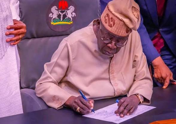 President Tinubu signing documents 